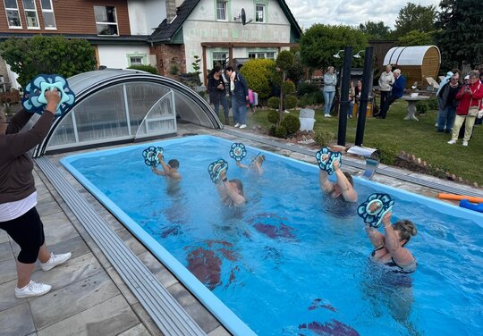 eine Gruppe Menschen macht Wassersport mithilfe von Aquadiscs