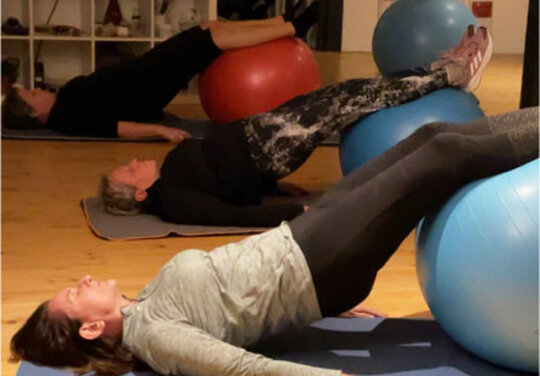 drei Damen machen Gymnastikball Fitness und haben ihre Beine auf dem Fitnessball