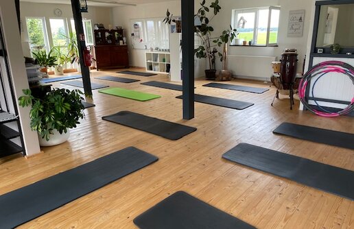 ein Fitness Raum mit Bodengymnastik Matten und mehrere Hula Hoop Reifen