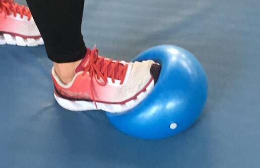 eine Person tritt auf einen Gymnastikball