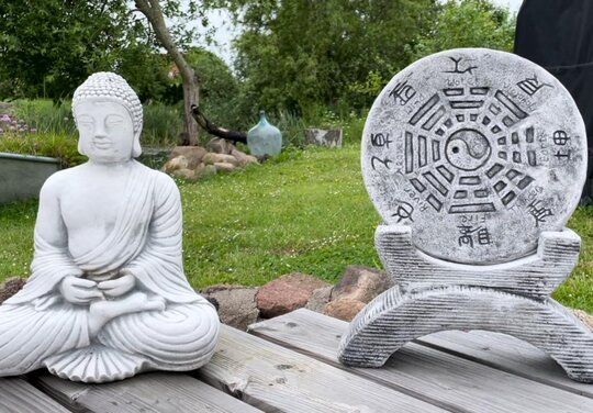 eine Buddha Statue und eine Taoistische Element Tafel