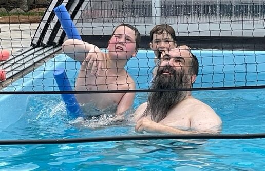 Kinder und ein Mann im Pool