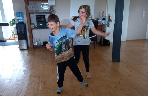 zwei Kinder die sich entgegengesetzt neigen und in Bewegung sind